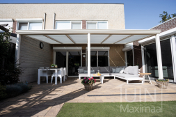 Pergola blanche avec protection solaire et toit en verre.